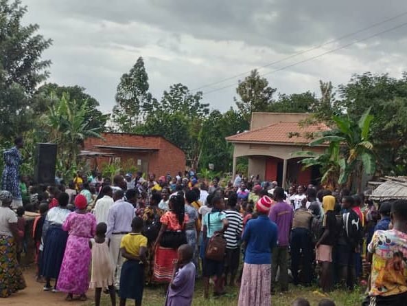 Community gathered under trees for a performance
