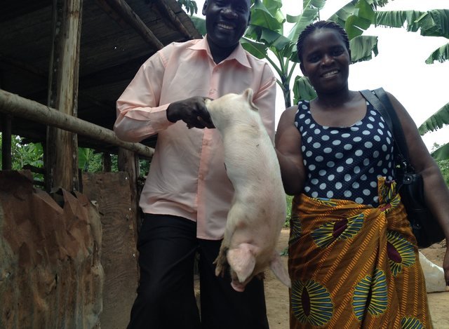 A trainee receiving a starter piglet for her piggery business