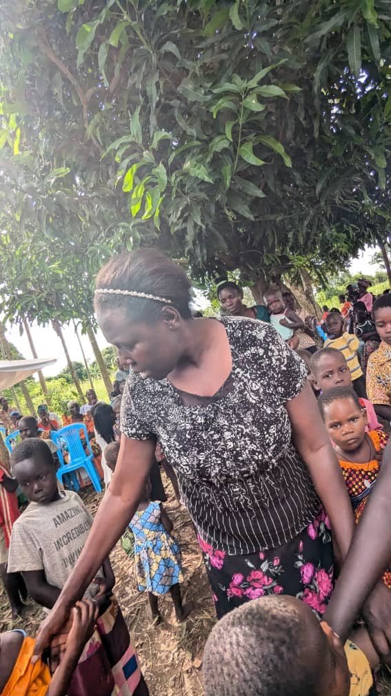 A Turikumwe volunteer reaching out to children during a community outreach visit